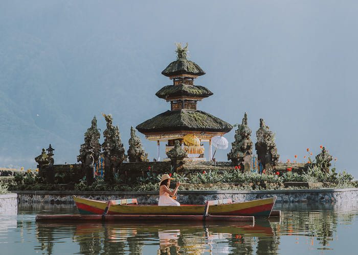 young-woman-traveler-paddling-on-a-wooden-boat-at-2023-11-27-05-19-33-utc-1.jpg